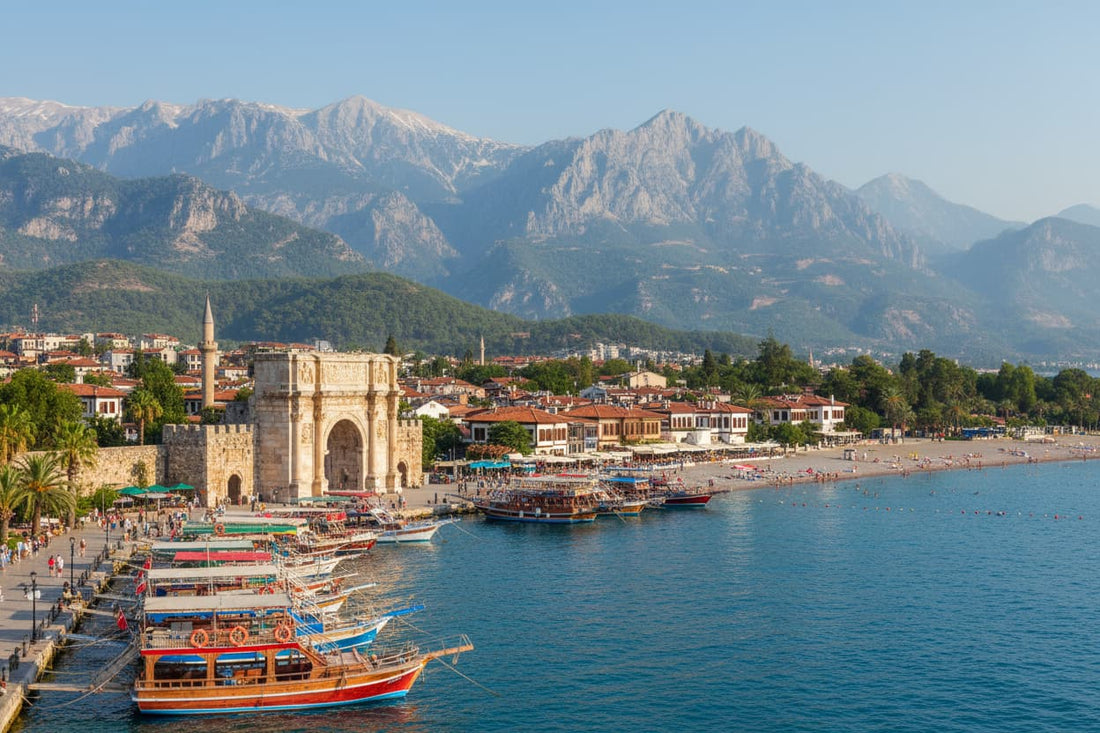 Antalya Turkey – ancient Roman harbour with colourful boats, Hadrian's Gate marble arch, dramatic Taurus Mountains backdrop, Konyaaltı beach turquoise Mediterranean sea and Kaleiçi old town cobblestone streets